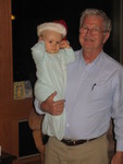 Brianna ready for bed and wearing a Santa hat, with Grandpa Darel