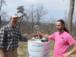 March 24: Retrofitting of the wind turbine foundations.  It's working, but just look at the difference between the hardware.  Josh's eyebolt is on the left, held by Mike; the one we're supposed to have is on the right, held by Howard.