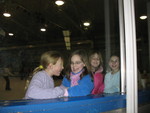 Girls acting silly through the window into the spectators' area