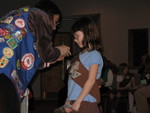 Miss Cindy is placing the pins on Kailyn's sash
