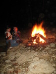 The kids enjoying the fire: warmth, good food, bright stars above, a cushy sofa of insulation where you can lean back against the house wall, and the expectation of a finished floor by morning. How could it be any better? 