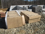 Oriented strand board, with chimney tiles and bricks for building up the garage wall in the background