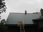 Phillip on the roof in the rain getting ready to install a sun tube