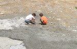 The kids 'helping' -- smoothing concrete in the driveway. (Much better than Connor falling into it, which I don't have a picture of because it happened so fast, but he was in up to his knees and had his boots full of it.)