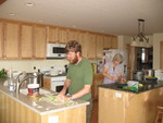 Don chopping vegetables for the chowder, and mom getting herself some breakfast.  She slept in really late, for a change -- dad stuffed her window with blankets and pillows so she didn't get light into the room, and she didn't know how late it was getting!