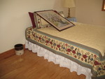 Guest room bed, with a picture waiting to be hung above the head of the bed