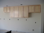 Kitchen upper cabinetry partially installed. The far left large cabinet turned out to be 2 inches too long, due to a measurement error, and will have to be fixed.